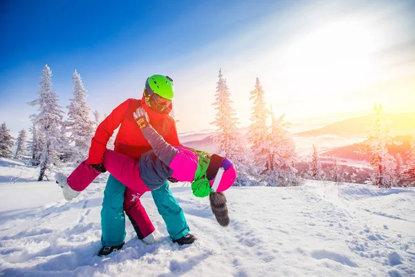 Liebespaar Frau und Mann amüsieren sich und albern im Winterwald herum. Skifahrer und Snowboarder vor blauem Himmel — Stockfoto