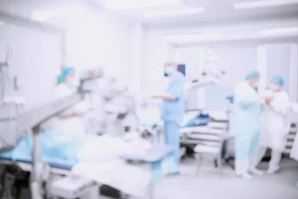 Abstract medical blurred background of operating room, patient lies on table, doctors working — Stock Photo, Image