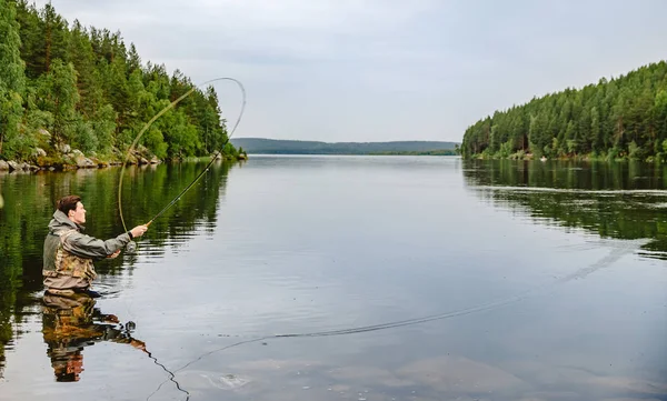 Pescador con caña pesca con mosca en río de montaña — Foto de Stock