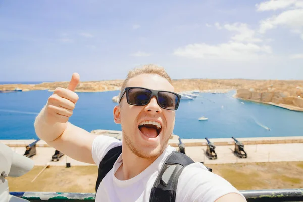 Valletta Malta glad turist man i glasögon gör selfie foto på bakgrund panorama pistol bay — Stockfoto