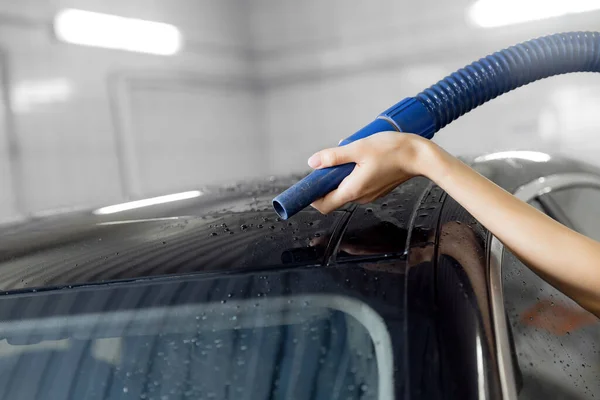 Servicio de lavado de autos express. Chica trabajador utiliza turbo secador para eliminar las gotas de agua —  Fotos de Stock