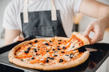 Yakın plan İtalyan taze pizza margherita, erkek şefin ellerinde zeytin.