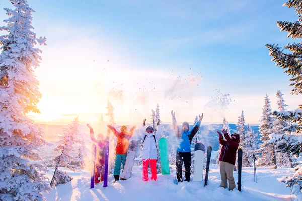 Grupo de snowboarders y esquiadores al amanecer con tablas de snowboard se regocijan de la nieve Luz del sol en el bosque de invierno amanecer. Concepto estilo de vida, viajes —  Fotos de Stock