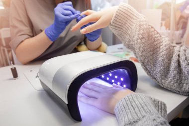 Master manikür salonunda çivi jel üzerinde vernik çizim uygular