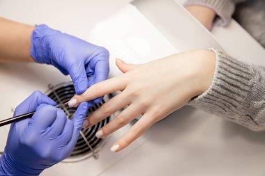 Master manikür salonunda çivi jel üzerinde vernik çizim uygular