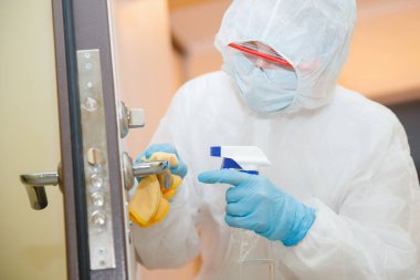 Evin dezenfeksiyon ve temizlik kapı kolları. Biyokimyasal kıyafetli mikroplar ve virüs enfeksiyonundan. Coronavirus koruma kavramı