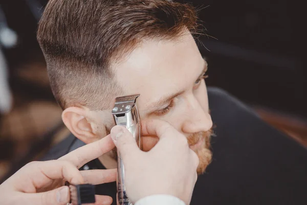 Peluquería corta hombres de pelo en la peluquería. Peluquero haciendo la barba correcta recorte máquina de afeitar eléctrica — Foto de Stock