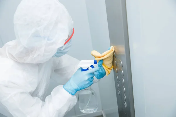 Concepto desinfección por coronavirus. Personas en materiales peligrosos haciendo limpieza en el apartamento del ascensor — Foto de Stock