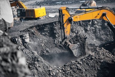 Kazıcı, sarı maden kamyonuna kömür yüklüyor. Açık maden endüstrisi