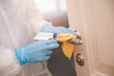 Evin dezenfeksiyon ve temizlik kapı kolları. Biyokimyasal kıyafetli mikroplar ve virüs enfeksiyonundan. Coronavirus koruma kavramı
