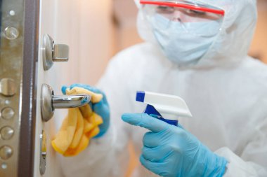 Evin dezenfeksiyon ve temizlik kapı kolları. Biyokimyasal kıyafetli mikroplar ve virüs enfeksiyonundan. Coronavirus koruma kavramı