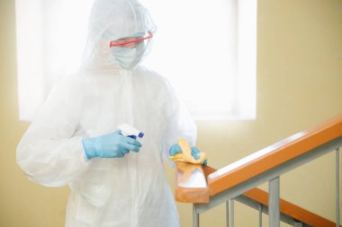 Coronavirüs dezenfeksiyonu. Tehlikeli maddeler kullanan insanlar apartmanın merdiven boşluğunu temizliyor.