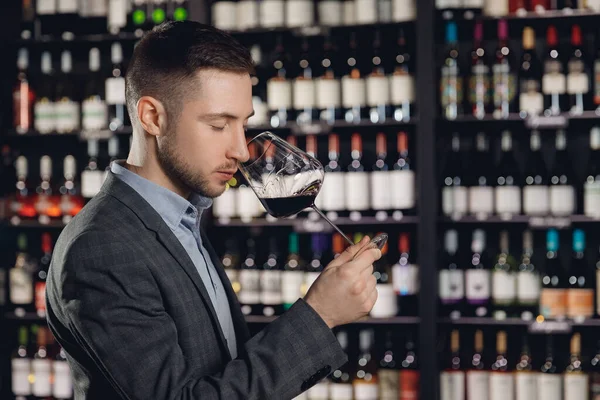 Винодел сомелье, нюхающий аромат красного вина в стакане — стоковое фото