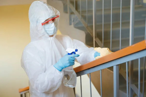 Concepto desinfección por coronavirus. Personas en materiales peligrosos haciendo limpieza en el hueco de la escalera del edificio de apartamentos — Foto de Stock