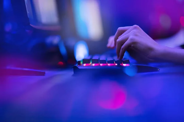Haker używa klawiatury, potrząsa palcami, żeby złamać hasło. Koncepcja bezpieczeństwa w Internecie, cyberatak. Neonowy niebieski kolor — Zdjęcie stockowe