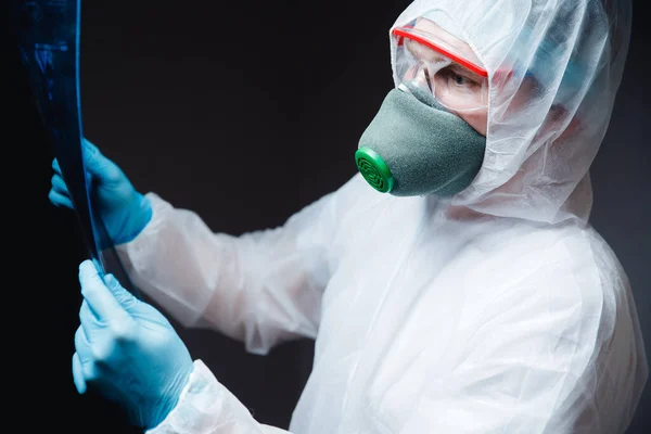 El hombre médico con lentes respiratorios protectores de materiales peligrosos blancos examina los efectos sobre los pulmones humanos y los órganos reproductivos neumonía coronavirus epidémico — Foto de Stock