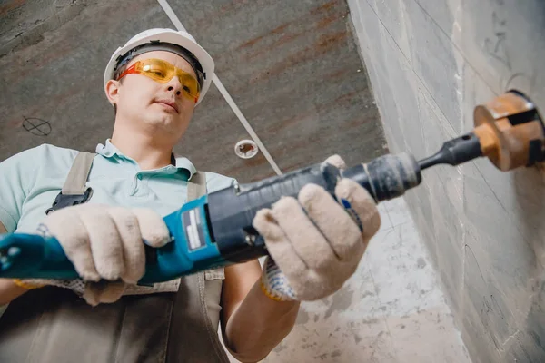 Építő munkás pneumatikus kalapács fúrja lyuk beton tégla fal gyémánt korona elektromos kábel, aljzat, kapcsoló — Stock Fotó