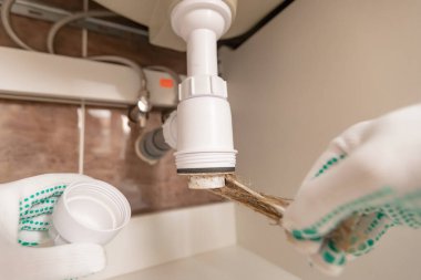 Profesyonel erkek tesisatçı lavabo borusundaki tıkanıklığı ortadan kaldırdı