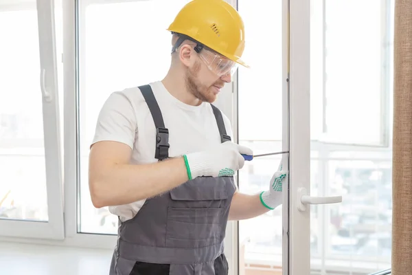Trabalhador instala janelas de plástico branco de bloqueio e ajuste de vedação — Fotografia de Stock