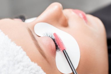 Kirpik uzatma prosedürü. Kadın usta tarakları kirpikleri