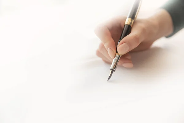 Молодая писательница пишет стихи с ручкой на листе бумаги, теплым солнечным светом — стоковое фото