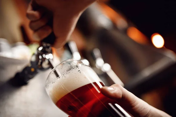 Closeup hand barman donker ambachtelijk koud bier giet in glas van kraan in pub — Stockfoto