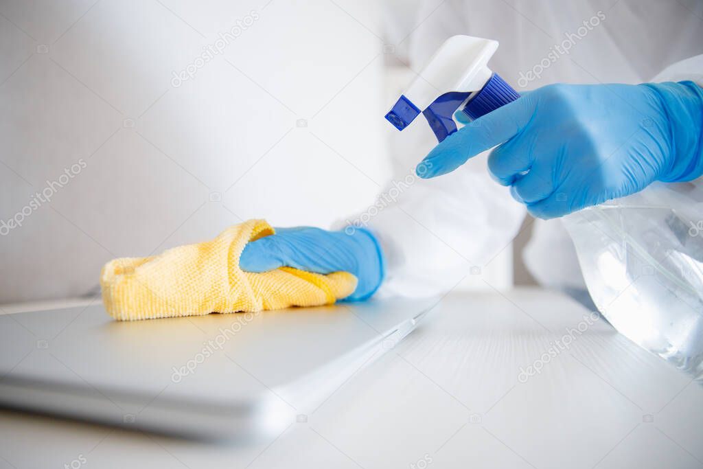 Cleaning service disinfects office, antiseptic processing of computer from coronavirus and germs