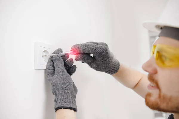 Electrician checks device for electricity voltage power outlet sockets — Stock Photo, Image