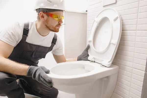 Encanador de instalação vaso sanitário no banheiro, trabalho no banheiro — Fotografia de Stock