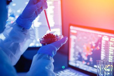 Eczane laboratuarında 2019 ncov Coronavirus aşısı üzerinde çalışan tıbbi biyomühendis. Mavi renk arkaplan