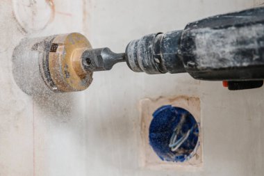 İnşaatçı işçi pnömatik çekiç delme delikleri beton tuğla duvar ve elektrik kablosu için elmas taç, soket, anahtar