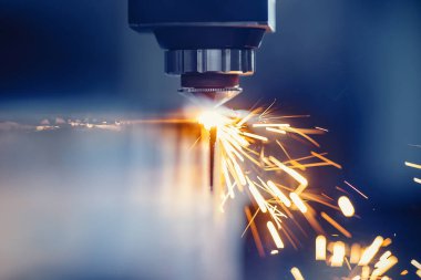 CNC gazı metal levha kesiyor, kıvılcımlar uçuşuyor. Mavi çelik rengi, modern endüstriyel teknoloji.