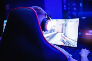 Neon rengi bulanık arka planda kişisel bilgisayarı olan profesyonel video oyunu stüdyosu. Yumuşak odak