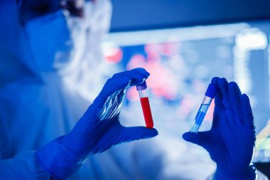 İşçi biyoloji laboratuvarı MERS-Cov Coronavirus 2019-NCoV virüsünün virüs modelini analiz ediyor. Mavi arkaplan