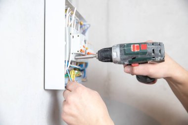 Electrician hand mounts consumer electric control panel switchboard for home enclosure for distribution and power electricity