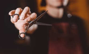 Yakın plan berber, klipsli saç makasıyla berber dükkanı işletiyor.