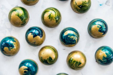 Yakın plan çikolata şekerlemeleri, mavi renkli, taşın altında beyaz lekeler, üst görünüm.