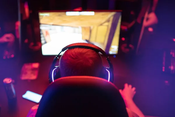 Sala de estudio profesional de cyber gamer con sillón de computadora personal, teclado para flujo en fondo borroso de color neón. Enfoque suave —  Fotos de Stock