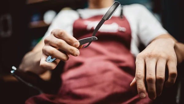 Scharfe Rasierklinge in den Händen eines professionellen Friseurs — Stockfoto