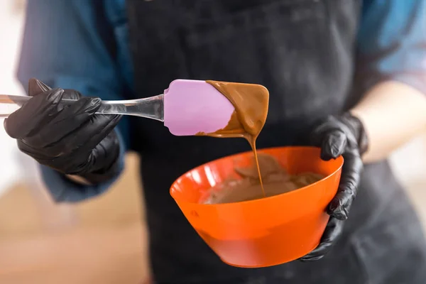 Pasticcere scioglie il cioccolato in ciotola per caramelle dolci — Foto Stock