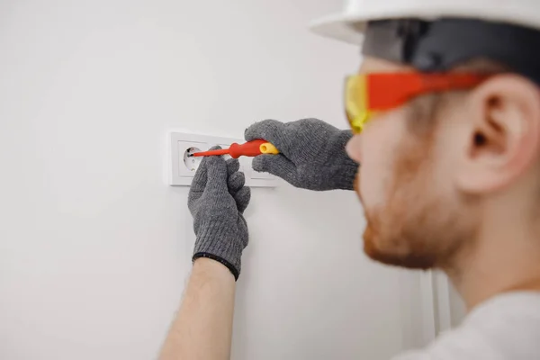 Electrician builder install screwdriver tool working switches and sockets — Stock Photo, Image