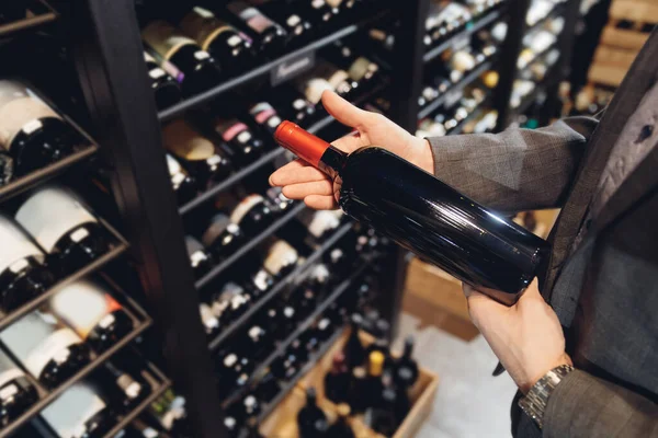 Barkeeper Sommelier pflückt Flasche Wein mit exquisiten Getränken vom Regal im Restaurant — Stockfoto