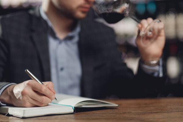 Сомелье мужчины дегустации красного вина и делать заметки аромат дегустации карты