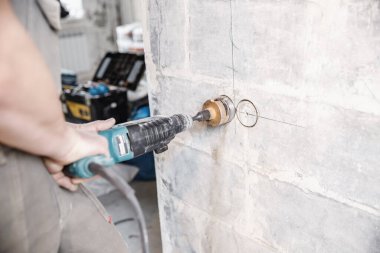 İnşaatçı işçi pnömatik çekiç delme delikleri beton tuğla duvar ve elektrik kablosu için elmas taç, soket, anahtar