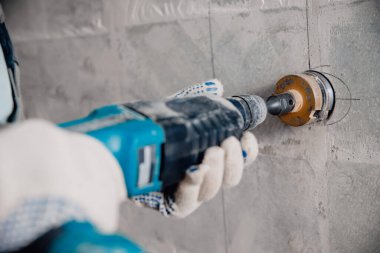 İnşaatçı işçi pnömatik çekiç delme delikleri beton tuğla duvar ve elektrik kablosu için elmas taç, soket, anahtar