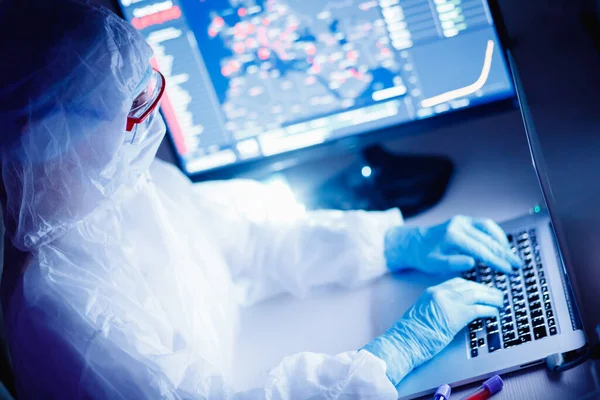 Analysis number of infected people in China and world from virus, doctor in protective chemical suit with respirator computer in laboratory