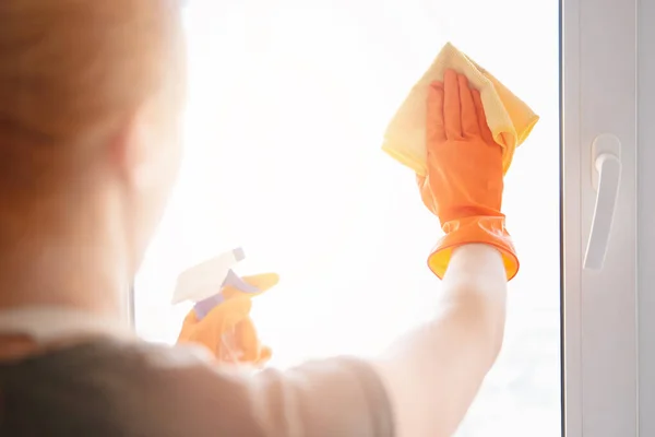Mulher de lavagem Janela de vidro com agente de limpeza e pano — Fotografia de Stock