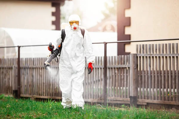 Tehlikeli madde giysileri, dezenfekte hizmetleri halk bahçesini temizleme, koronavirüs salgınından kaynaklanan yüzey tedavisinde uzman. — Stok fotoğraf