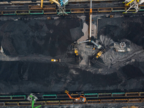 Loading coal anthracite mining in port on cargo tanker ship with crane bucket of train. Aerial top view