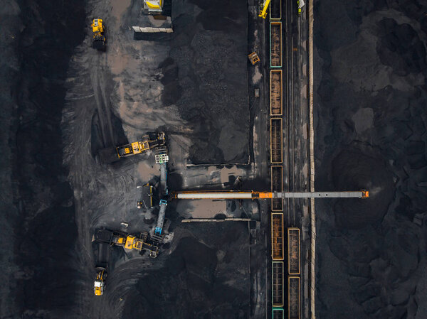 Loading coal anthracite mining in port on cargo tanker ship with crane bucket of train. Aerial top view
